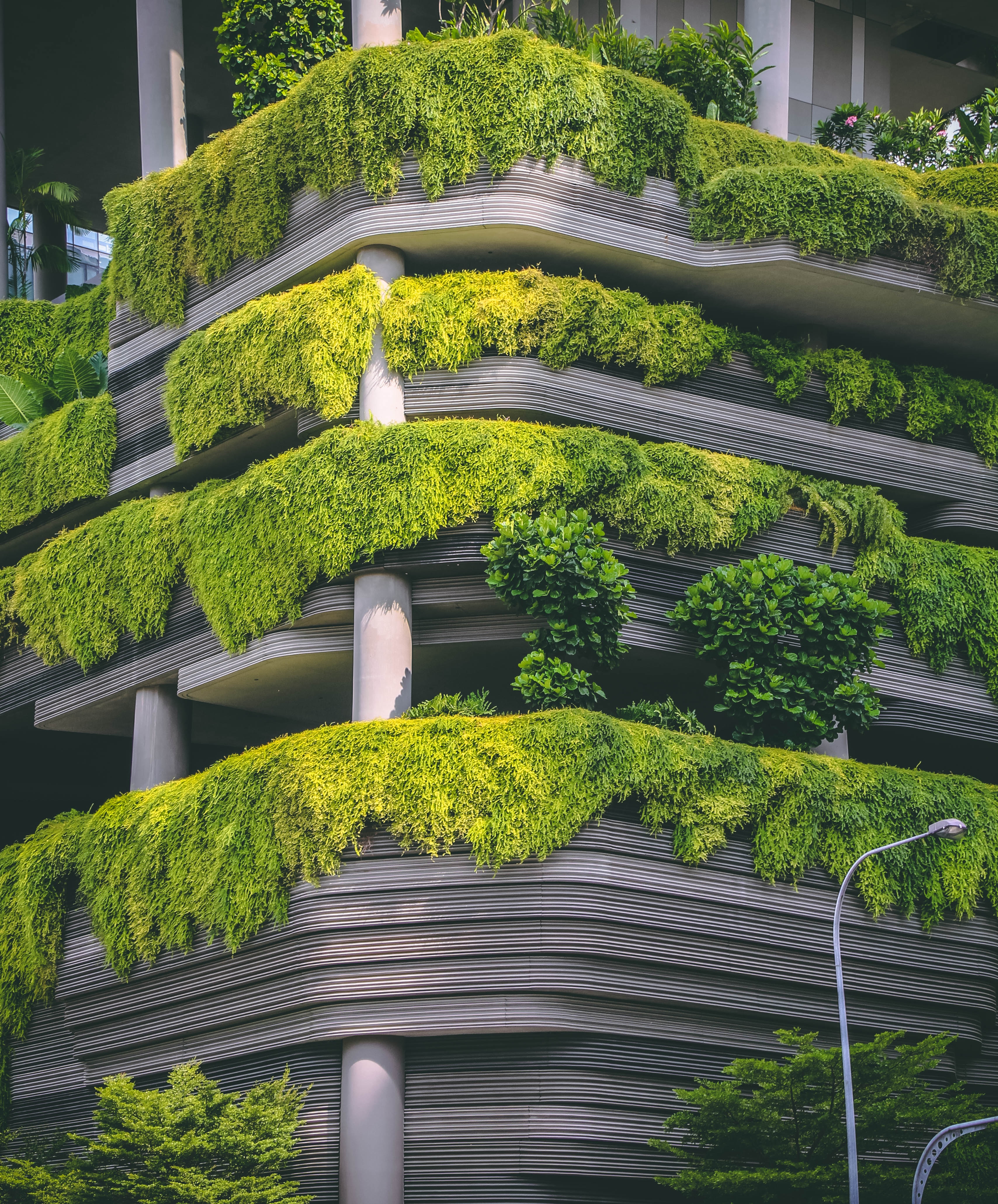 a building covered in plants and hedges.